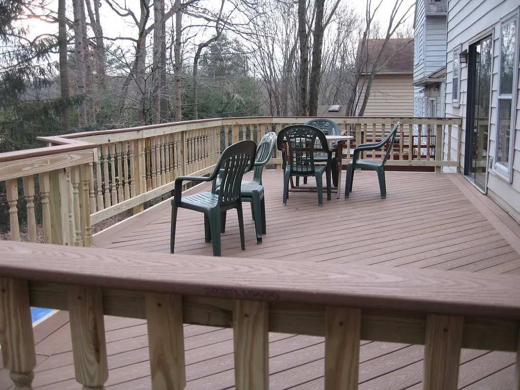 Wood deck with railings and patio chairs