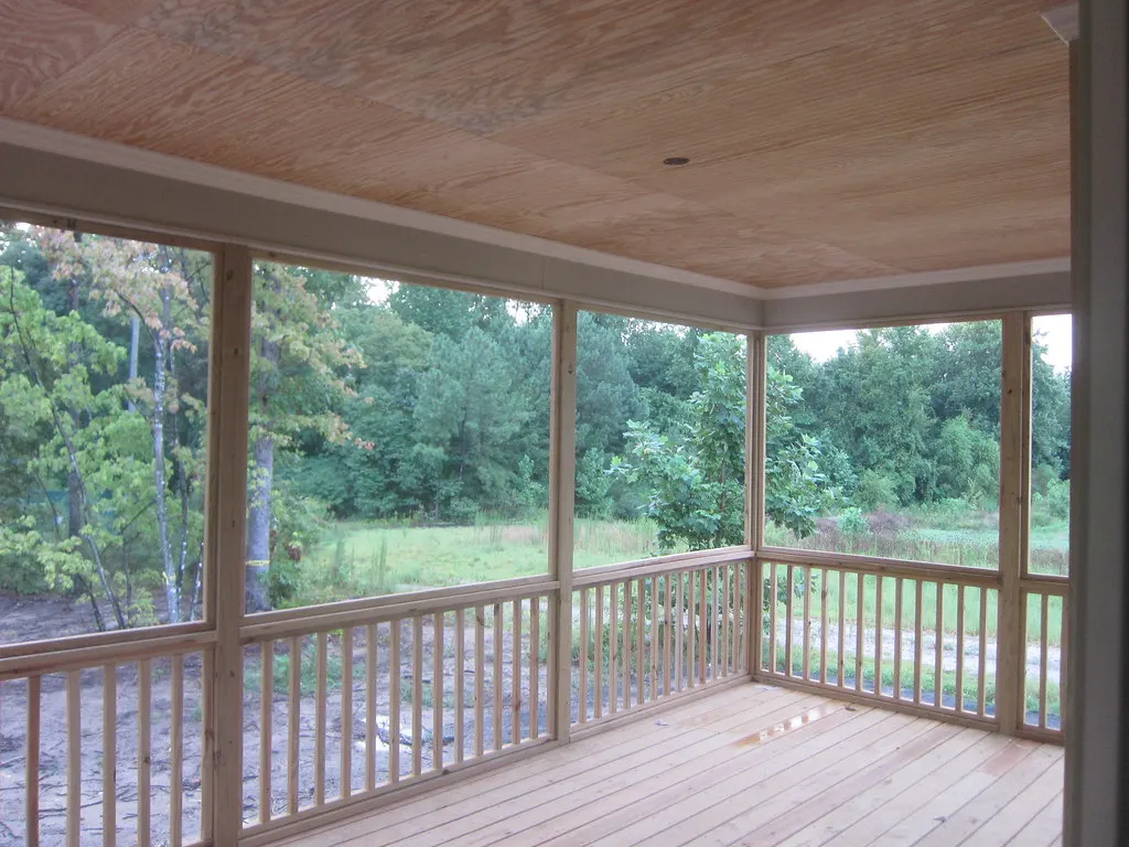 Screened porch looking out to a green backyard